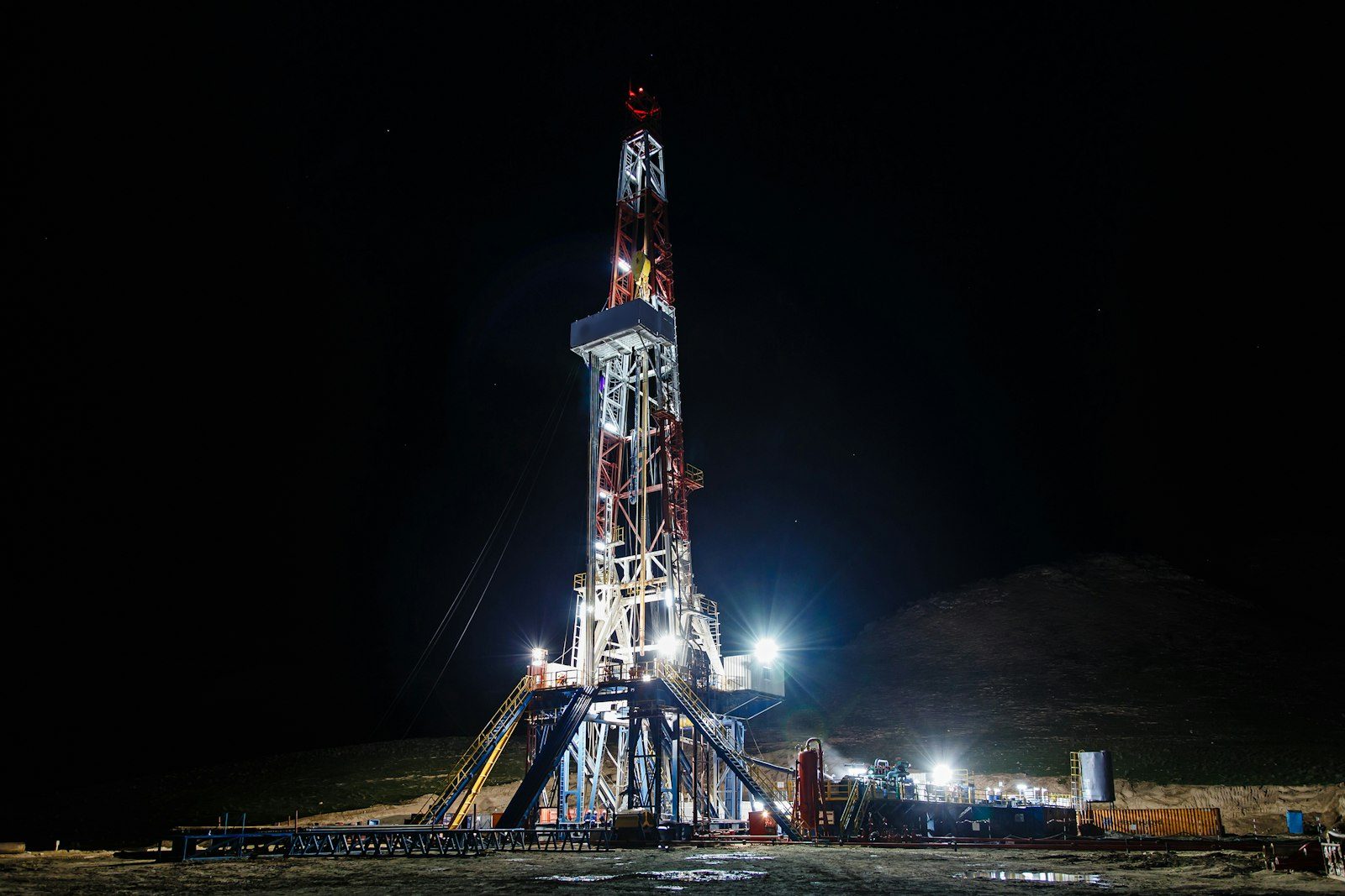 Floodlit onshore drilling rig at night