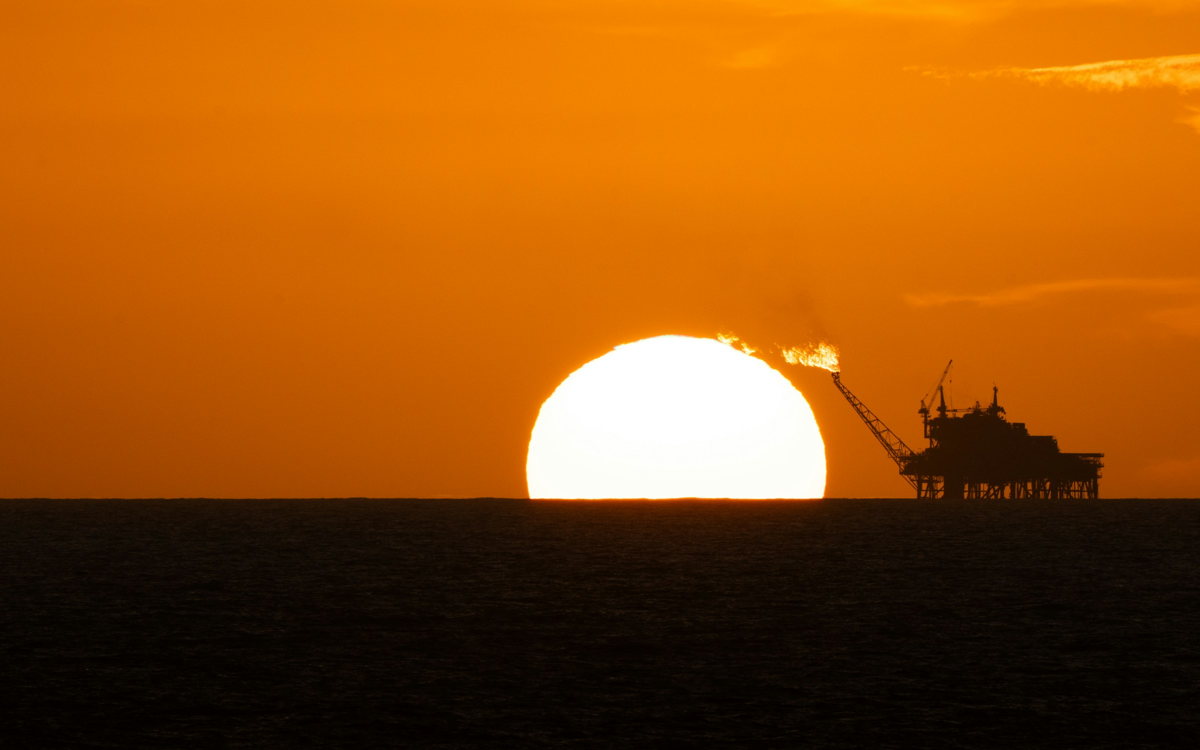 Offshore platform silhouetted against a setting sun