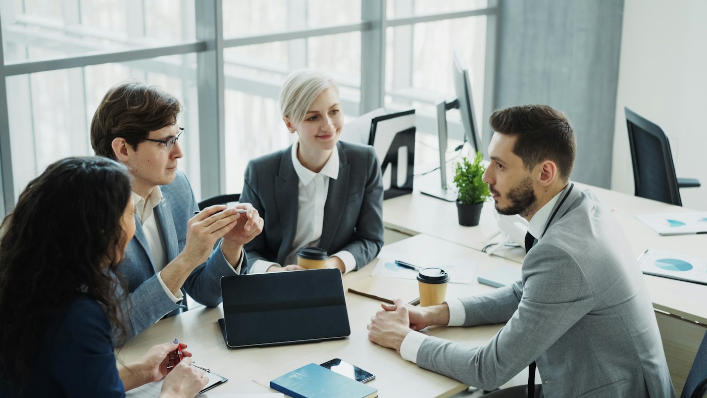 Project team meeting around a table in an office