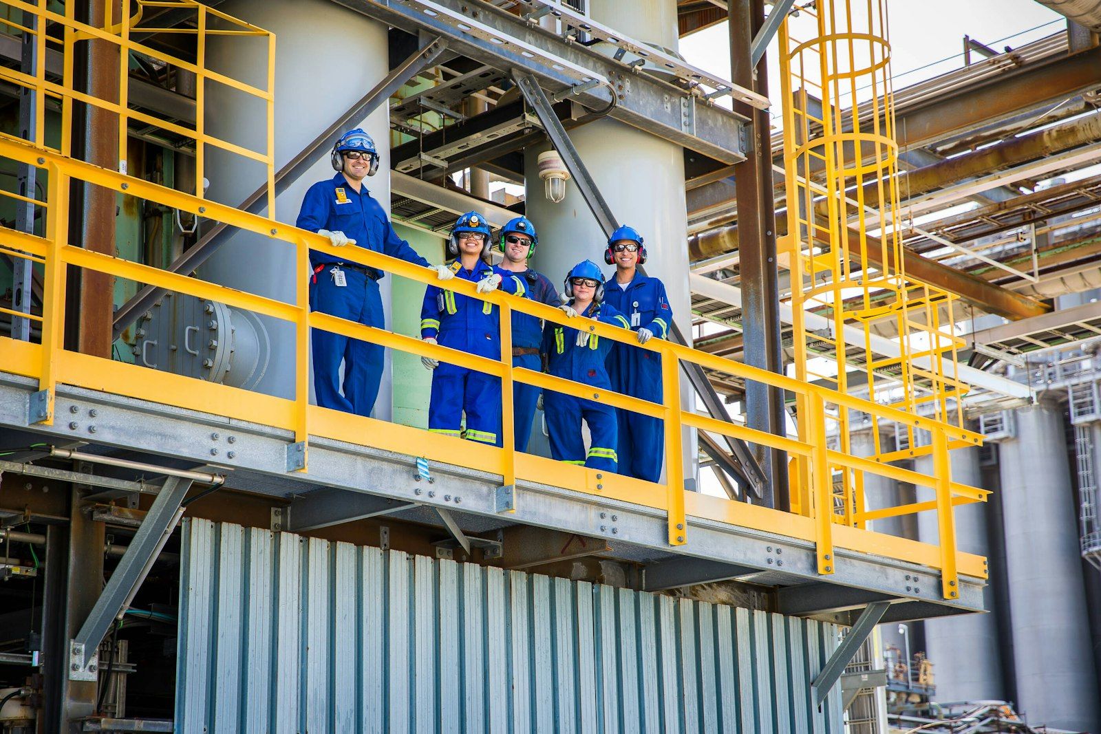 Crew in hard hats and coveralls on an industrial site